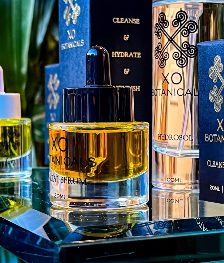 XO Elements bottles on a mirrored surface with boxes behind